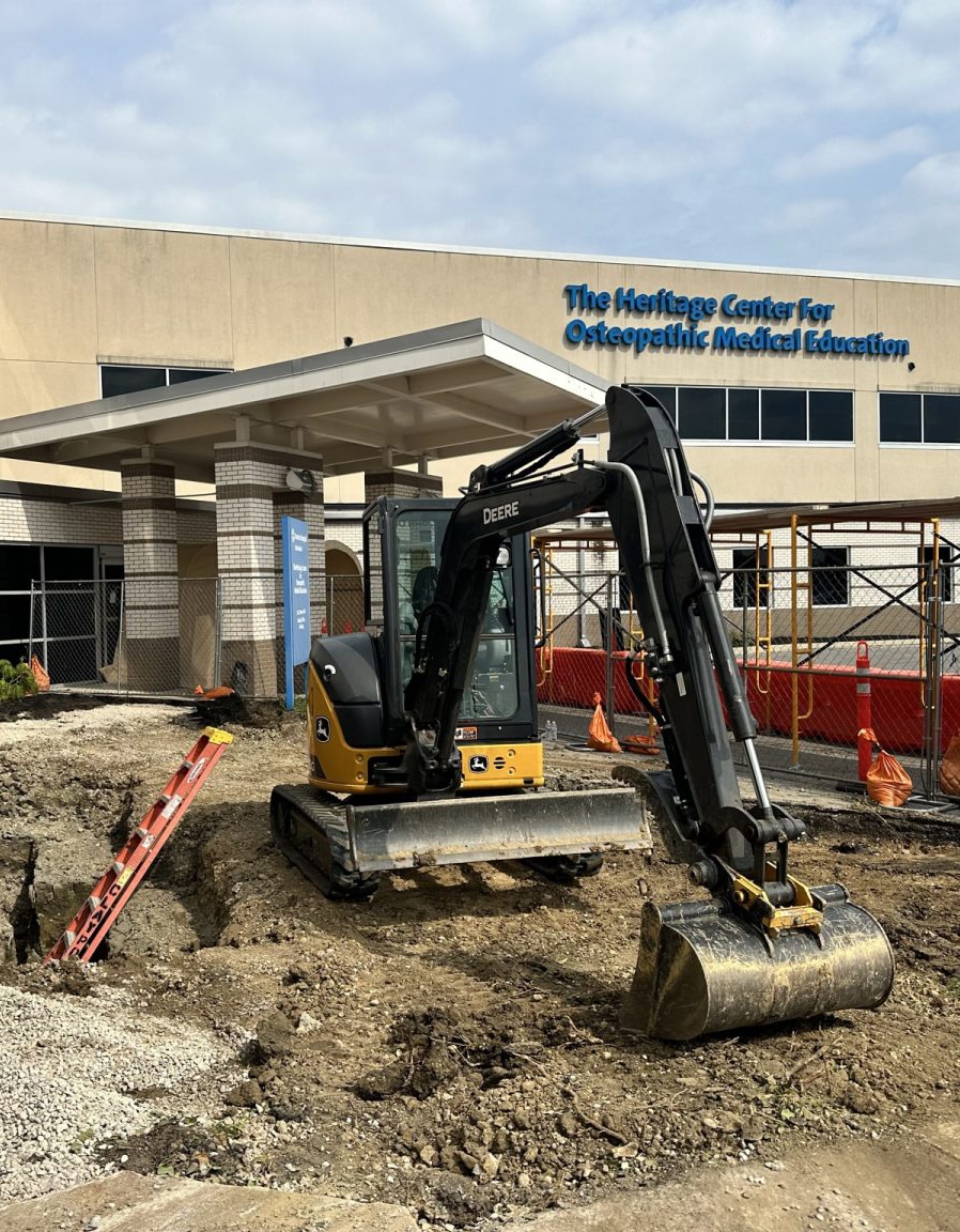 John Deere Excavator at Construction Site John Deere excavator positioned at a construction site near a medical education center.